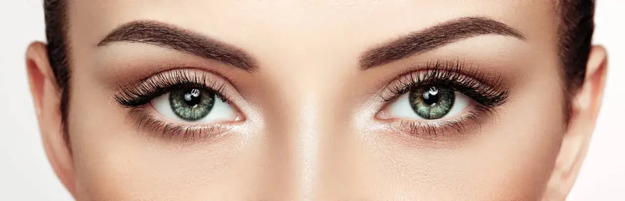 Yeux verts intenses, cils longs et &eacute;pais. Un l&eacute;ger mascara qui coule sous l'&oelig;il gauche ajoute une touche de r&eacute;alisme.