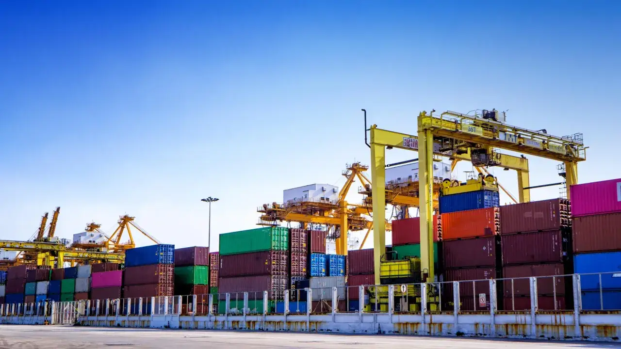 Containerhafen mit Kränen und vielen Frachtcontainern. Wichtiger Umschlagplatz für den globalen Handel, abgesichert durch marine insurance.