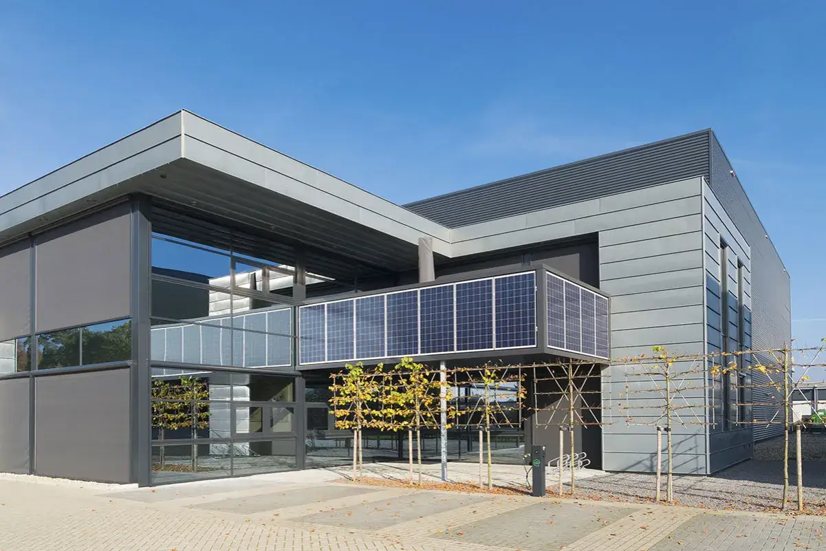 Edificio moderno con fachada de cristal y paneles solares integrados, creando un dise&ntilde;o innovador de ventanas fotovoltaicas.
