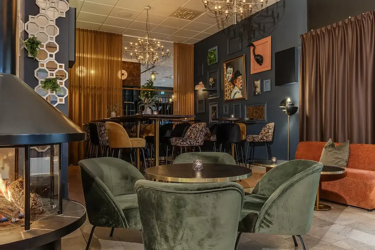 Mysig lounge med öppen spis och konst på väggarna. Välkommen till värdshuset Stopet för en avkopplande stund.