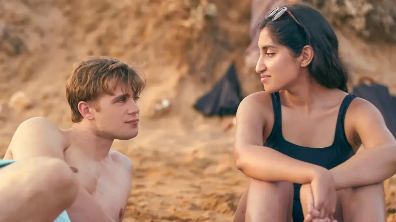 Młoda para, Emma i Dexter, siedzą na plaży, rozmawiając o swoim związku. Scena z serialu 
