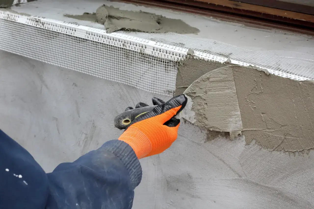 Application d'enduit sur une armature en treillis pour l'isolation extérieur.