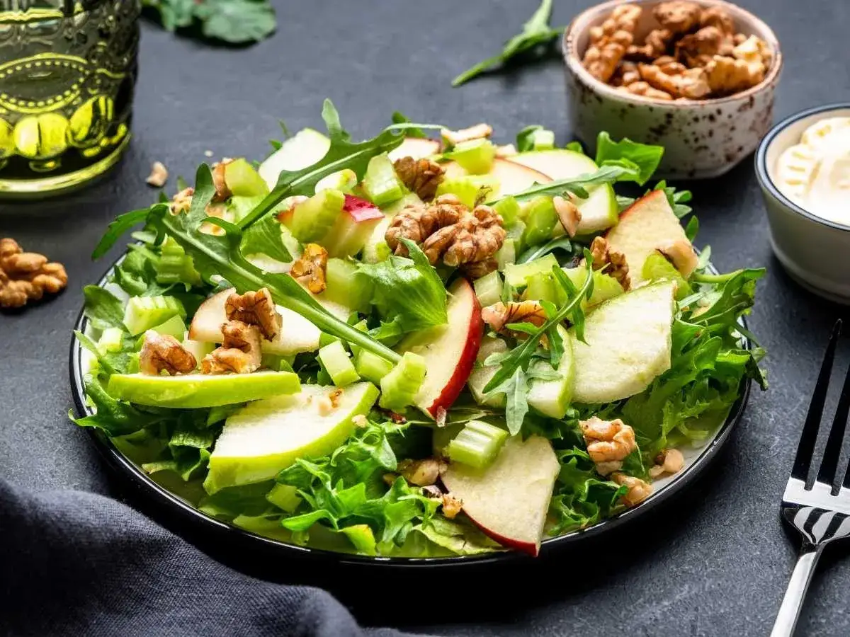 Ensalada Waldorf fresca con manzana verde, apio crujiente, nueces y rúcula. Un clásico delicioso y saludable.