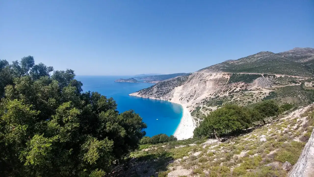 Widok na zatokę Myrtos, jedno z najpiękniejszych miejsc na Kefalonii. Turkusowa woda, biała plaża i skaliste zbocza tworzą zapierający dech w piersiach krajobraz.