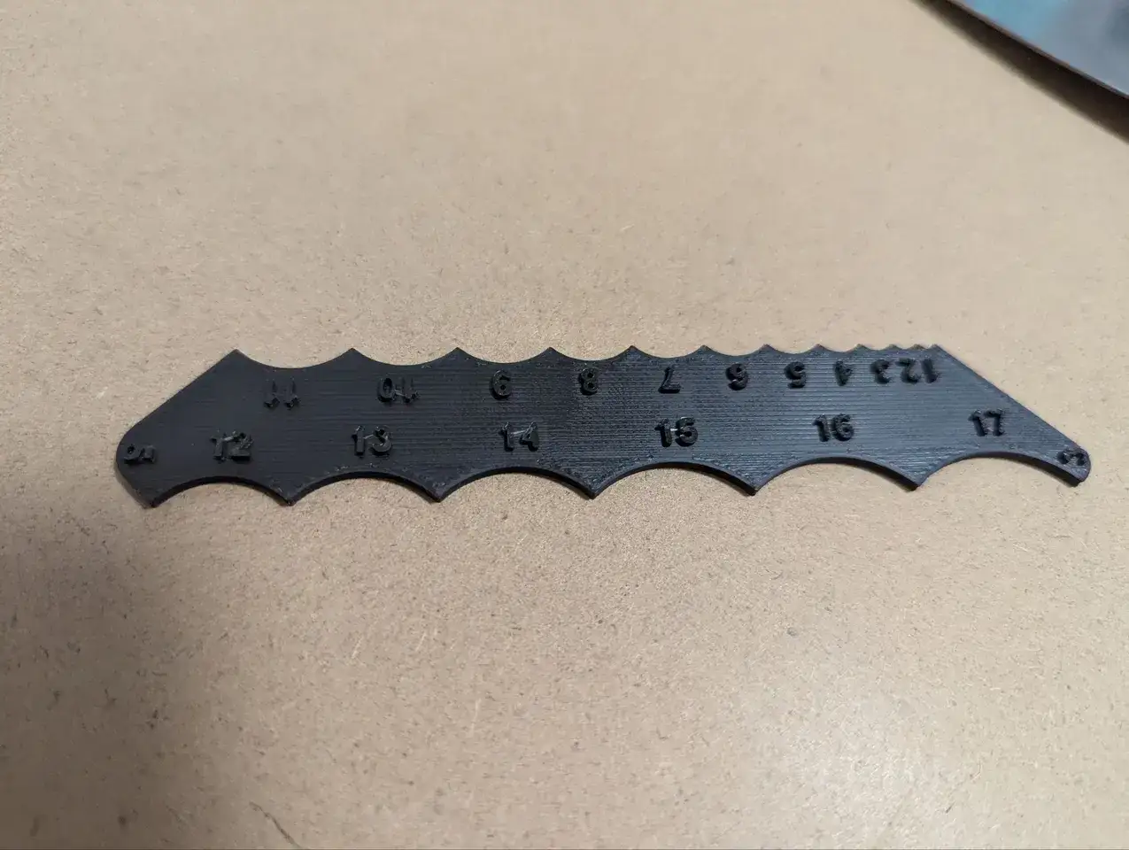 A black gauge with numbers 1-17, designed to help you measure rounded corners.