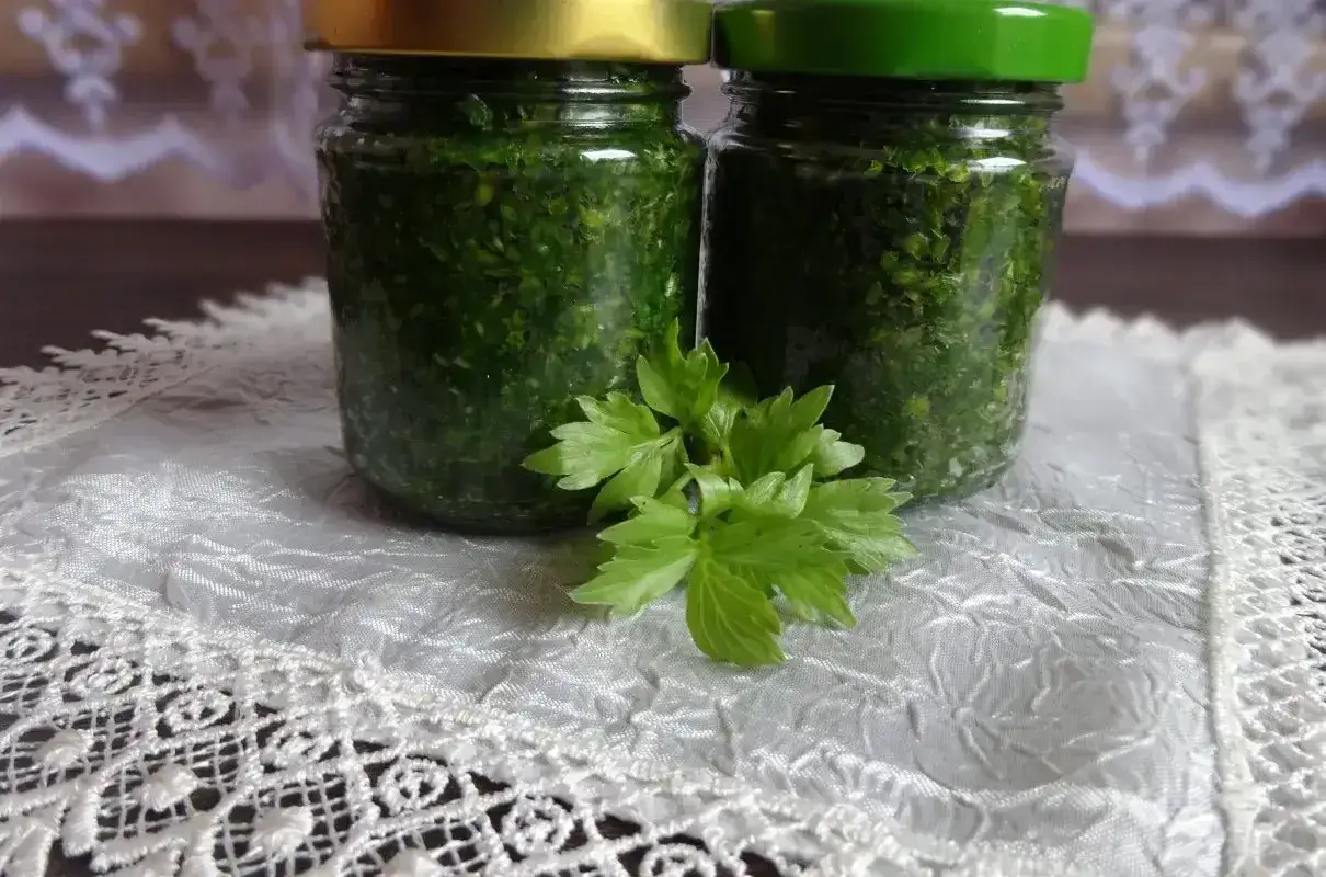 Dwa słoiki z posiekanym lubczykiem, gotowe do mrożenia. To świetny sposób, by cieszyć się jego aromatem przez cały rok.