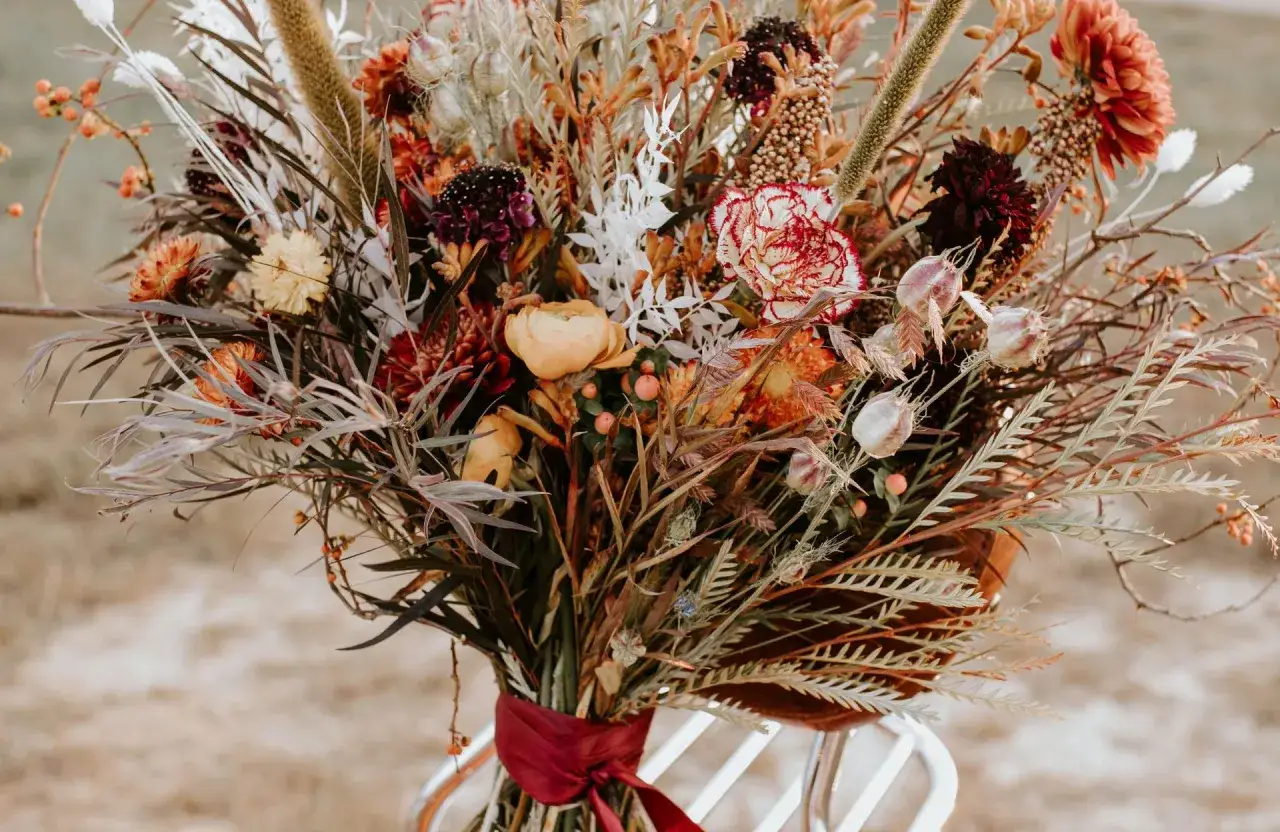 Magnifique bouquet de fleurs s&eacute;ch&eacute;es aux tons chauds, parfait pour une d&eacute;coration mariage automne. Des pampas, des dahlias et des baies orang&eacute;es cr&eacute;ent une ambiance rustique et &eacute;l&eacute;gante.