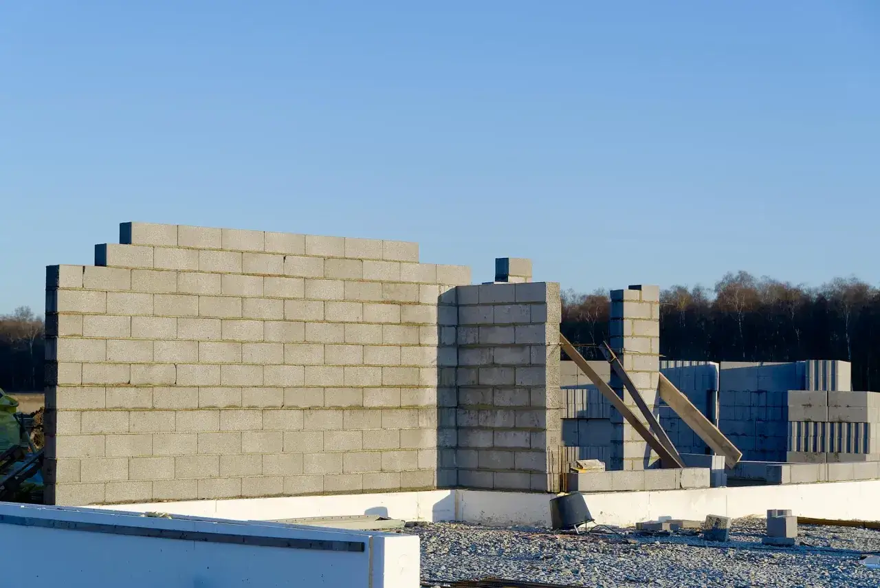 Budowa domu z bloczków betonowych. Widoczny fragment ściany z betonowych pustaków, z myślą o maksymalnym otworze bez nadproża.