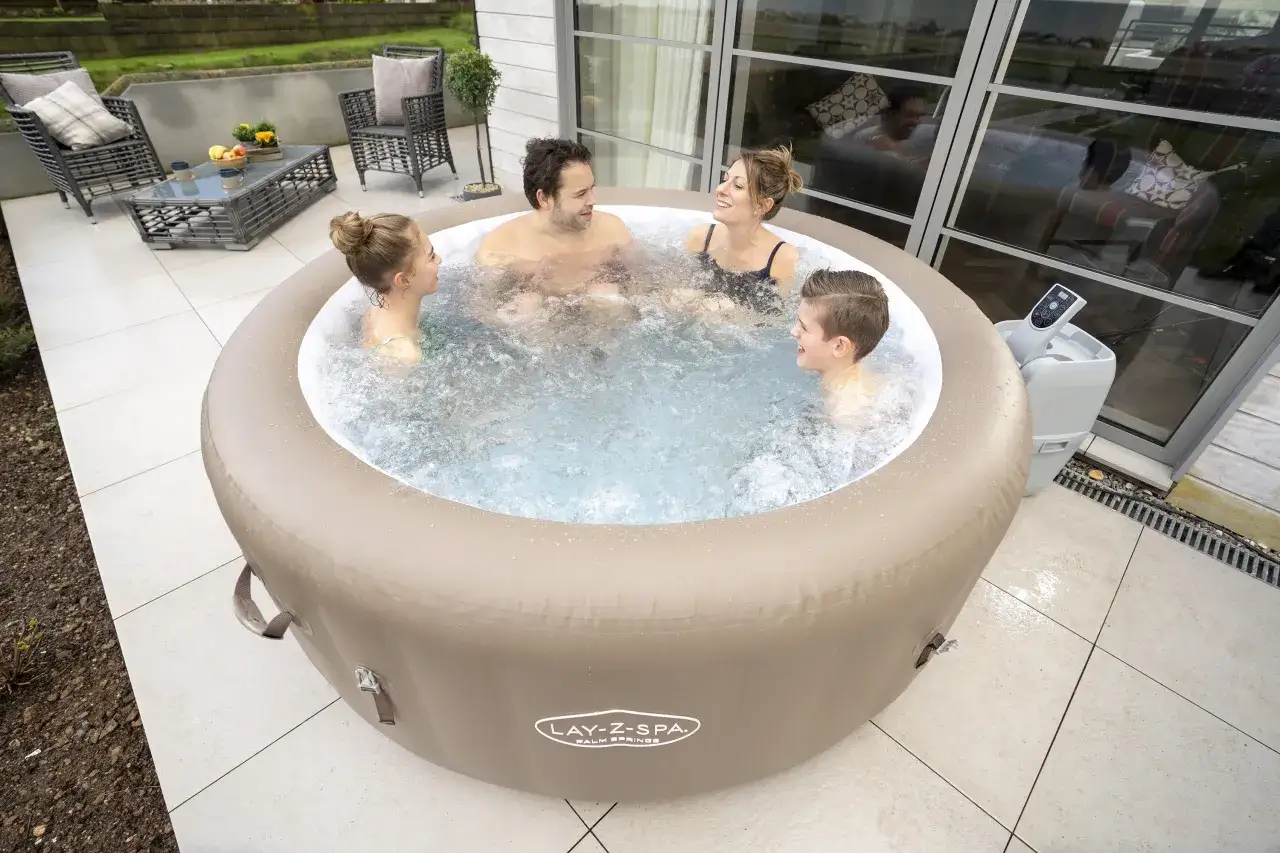 Rodzina cieszy się relaksem w jacuzzi Lay-Z-Spa Palm Springs na tarasie.