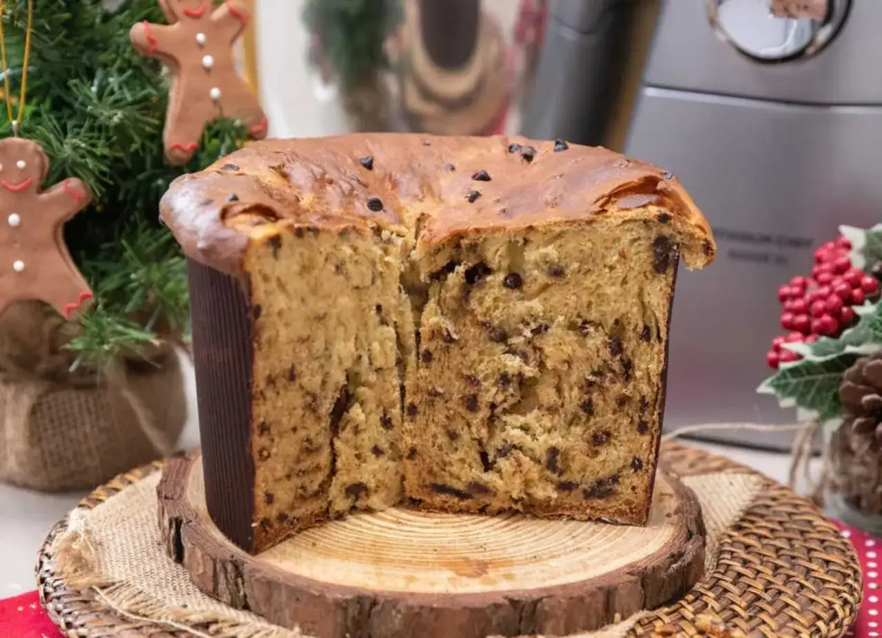 Un soffice panettone al cioccolato, tagliato a metà, mostra la sua morbidezza. Un'idea su come si fa il panettone per le feste.