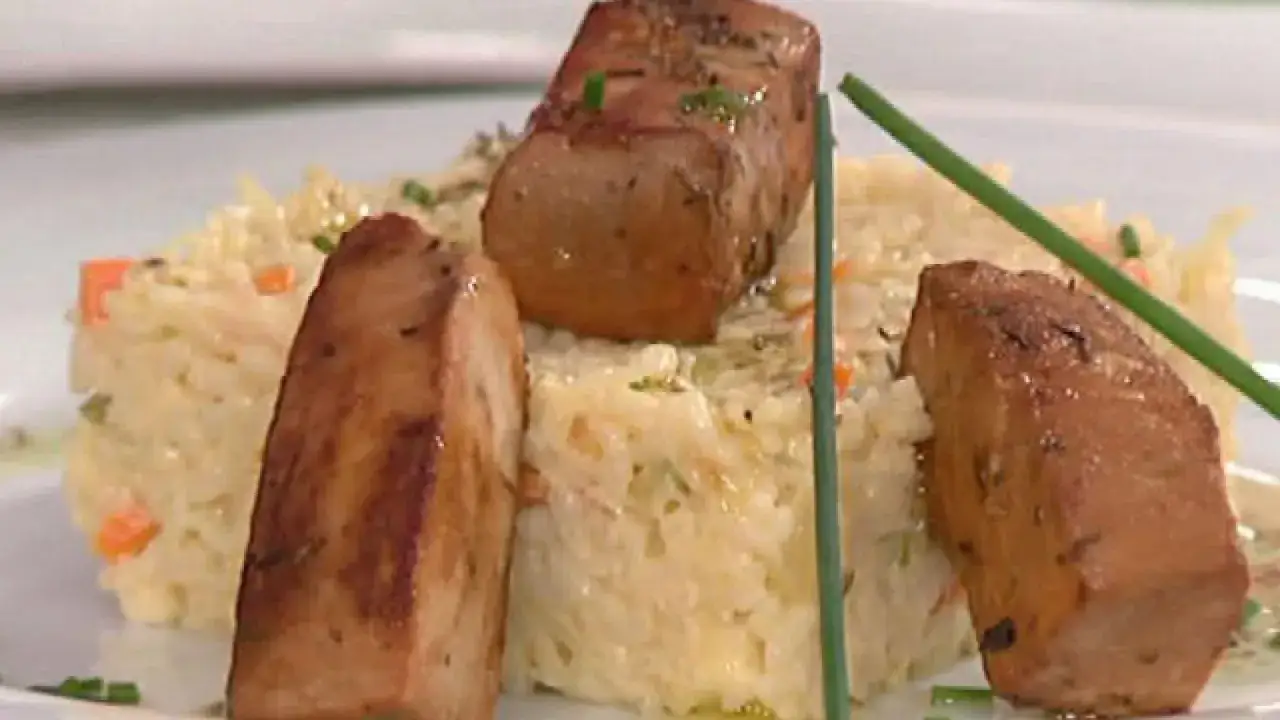 Delicioso risotto de verduras cremoso con trozos de carne dorada y hierbas frescas.
