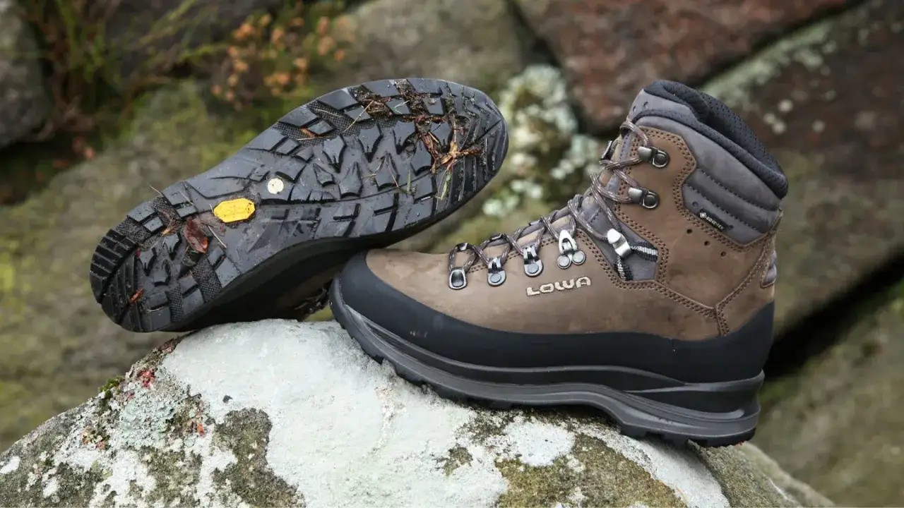 Hiking boots with a synthetic upper, meaning they're made from man-made materials for durability and water resistance, sit on rocks.