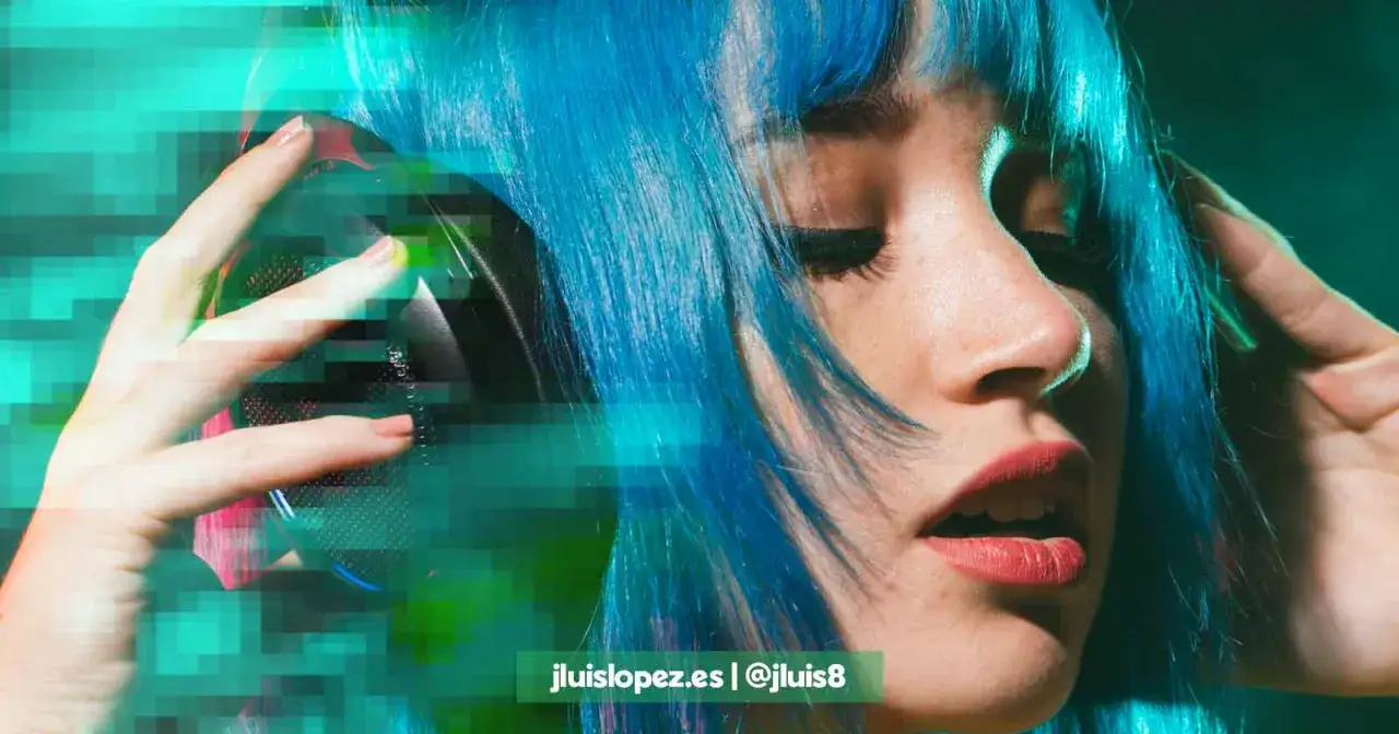 Chica con pelo azul vibrante escuchando m&uacute;sica con auriculares. Ideal para encontrar m&uacute;sica para descargar sin copyright.
