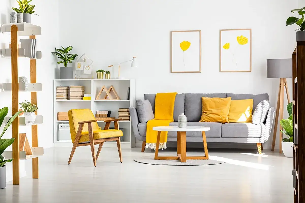 Un soggiorno moderno dove il grigio e giallo che colore esce, con divano, poltrona e cuscini in tonalit&agrave; vivaci.