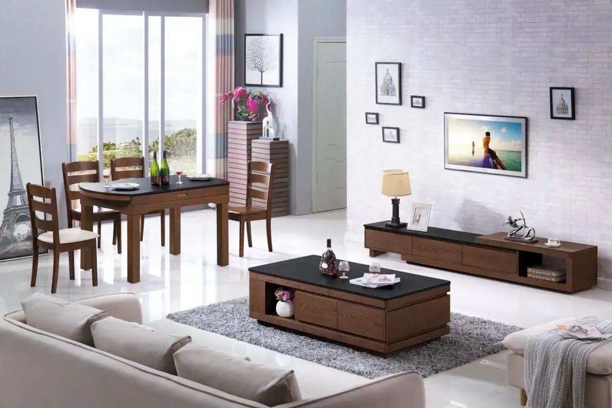 Ett modernt vardagsrum med ett elegant soffbord set i tr&auml; och svart, en soffa, TV-b&auml;nk och matgrupp.