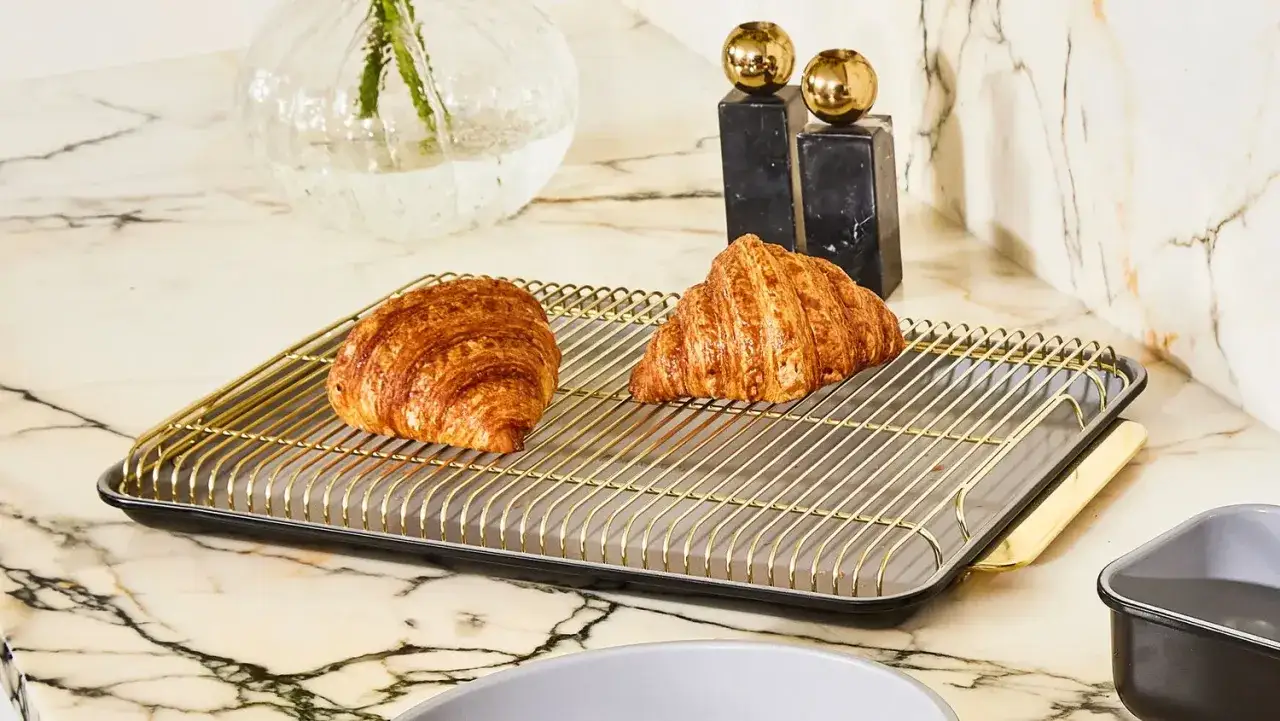 Dwa chrupiące croissanty na złotej kratce, idealne do podgrzania z funkcją grill w piekarniku.