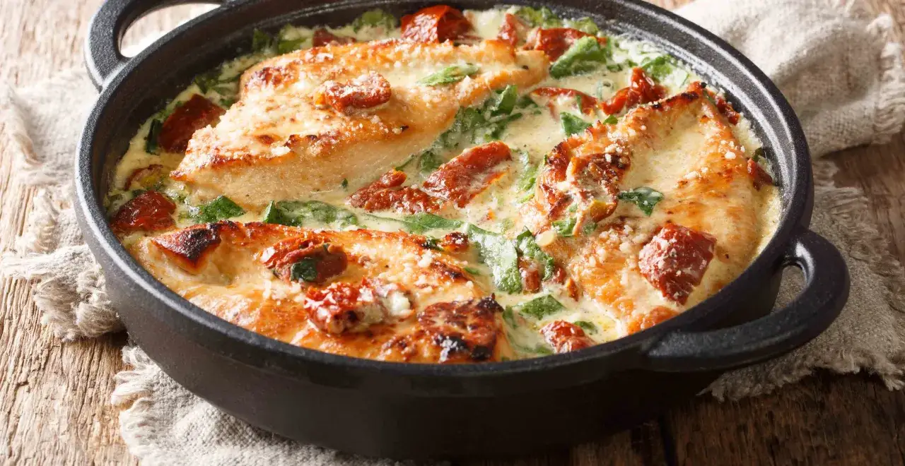 Hähnchenbrust in cremiger basilikum sahne sauce mit getrockneten Tomaten und Spinat, bestreut mit Parmesan.