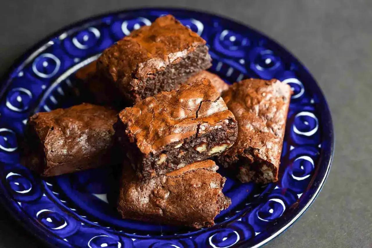 F&auml;rska, sega brownies med n&ouml;tter p&aring; en bl&aring;m&ouml;nstrad tallrik. Perfekt f&ouml;r ett enkelt brownie recept.