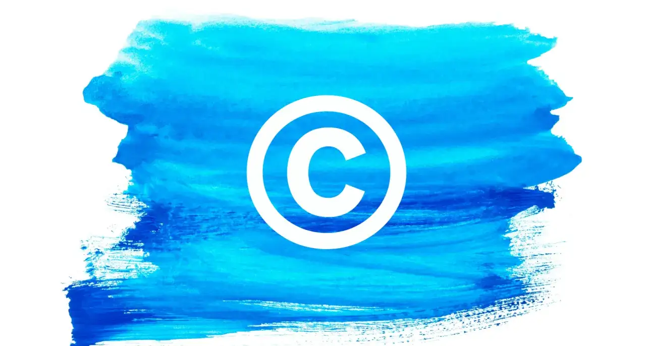 Symbol prawa autorskiego na tle błękitnego pociągnięcia pędzla. Czy nowe przepisy o prawie autorskim pozwolą artystom na blokowanie treści w internecie?