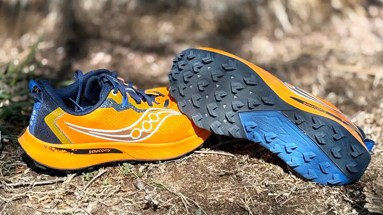 Leuchtend orangefarbene Saucony Trailrunning Schuhe mit tiefem Profil für Grip im Gelände. Perfekt für Abenteuer abseits befestigter Wege.