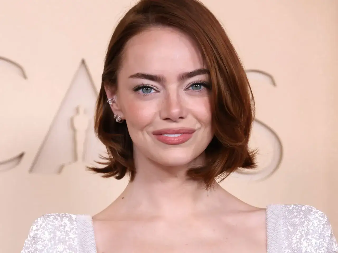 Emma Stone con capelli mossi e un look che mostra come dare volume ai capelli corti.