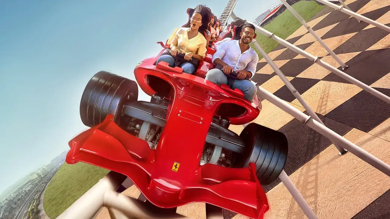 Para z ekscytacją jedzie najszybszą kolejką na świecie, która wygląda jak bolid Ferrari.
