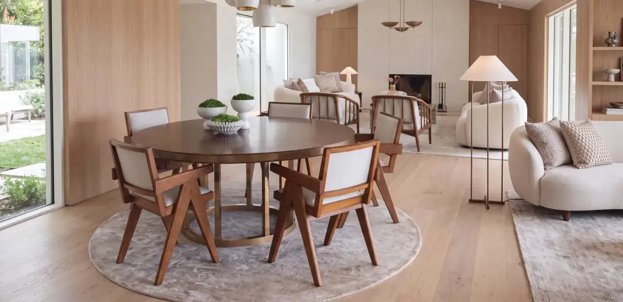 Tavolo da pranzo rotondo in legno con sedie moderne. La sua altezza è perfetta per creare un'atmosfera accogliente.