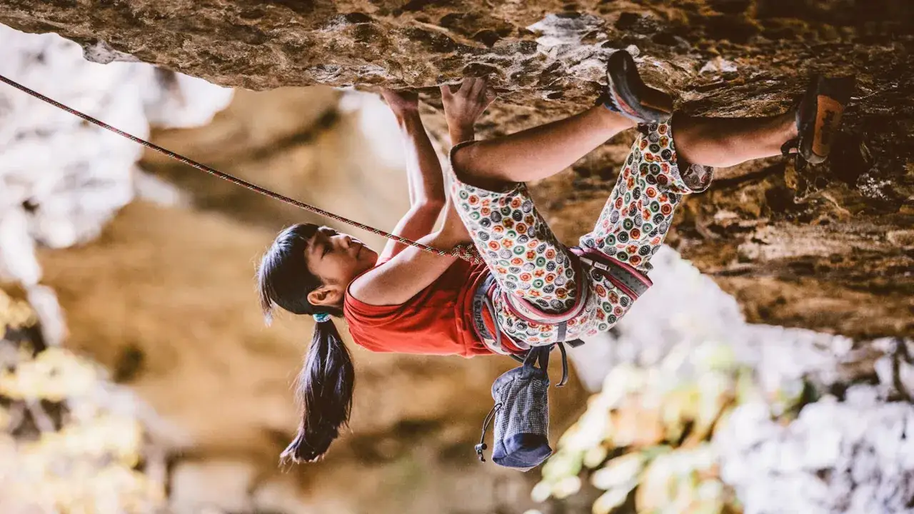 Ashima Shiraishi, escalando una roca con determinaci&oacute;n, su cuerpo &aacute;gil desaf&iacute;a la gravedad.
