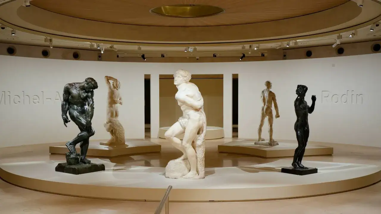 Exposition de plusieurs œuvres d'art de Auguste Rodin, dont des sculptures en bronze et en marbre, présentées dans un musée.