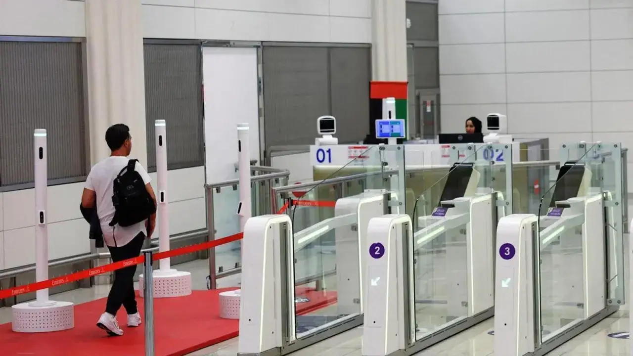 Podróżny z plecakiem przechodzi przez bramki na lotnisku w Zjednoczonych Emiratach Arabskich, gdzie wiza jest sprawdzana.