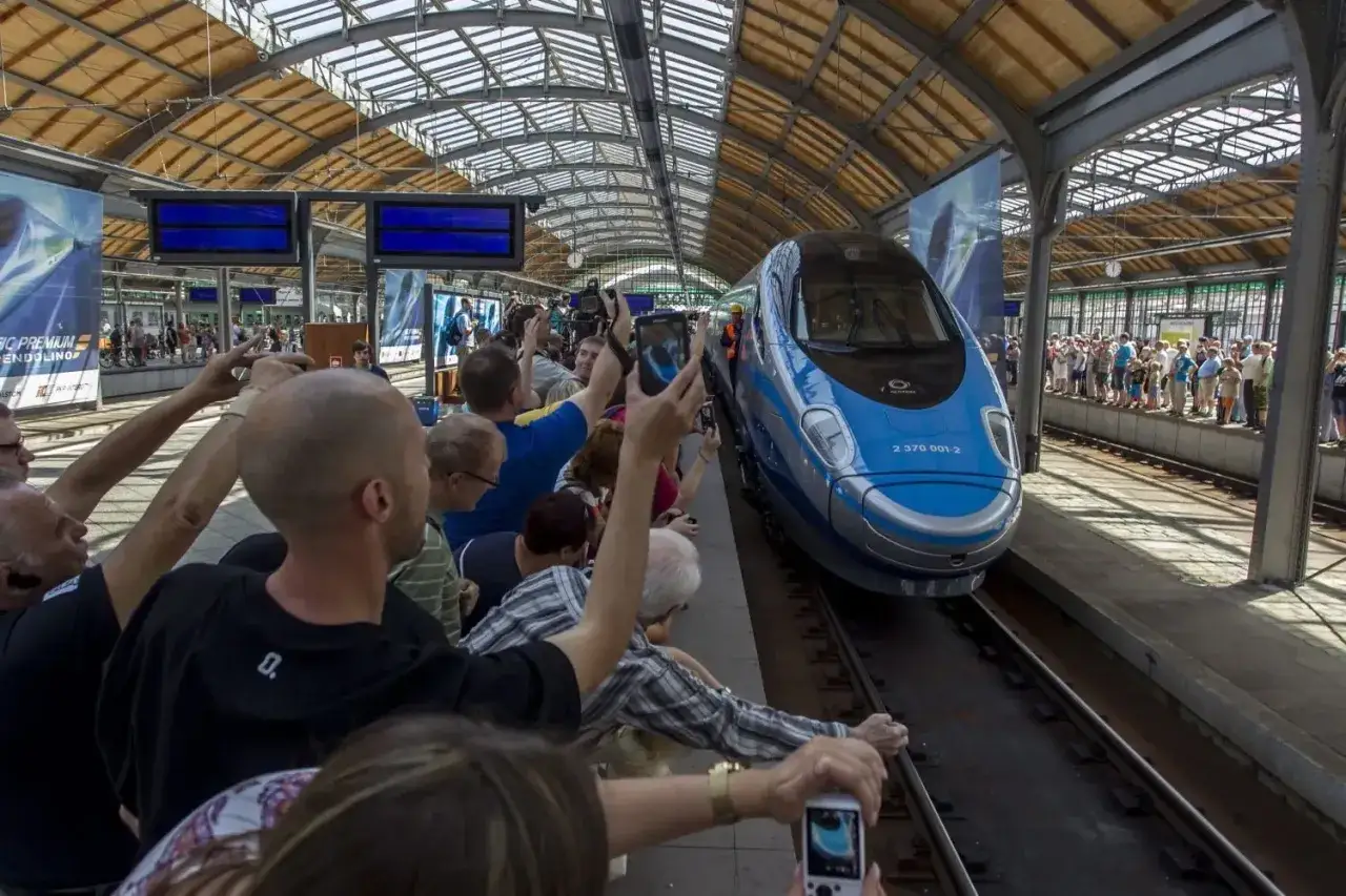 Menschen am Bahnhof fotografieren einen blauen Hochgeschwindigkeitszug. Vielleicht ist dies die Ankunft eines Zuges, der mit dem Deutschlandticket nach Polen f&auml;hrt.