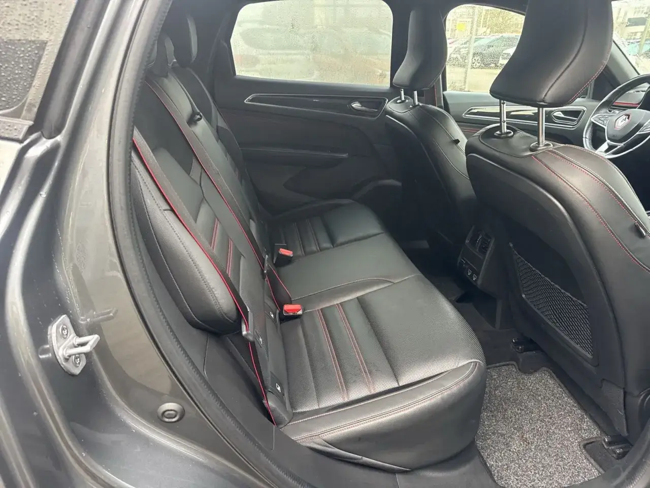 Rückbank eines Renault Arkana mit roten Nähten. Keine sichtbaren Renault Arkana Probleme, nur ein sauberer Innenraum.