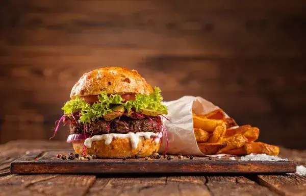 apetyczny domowy burger wołowy z warzywami na drewnianej desce