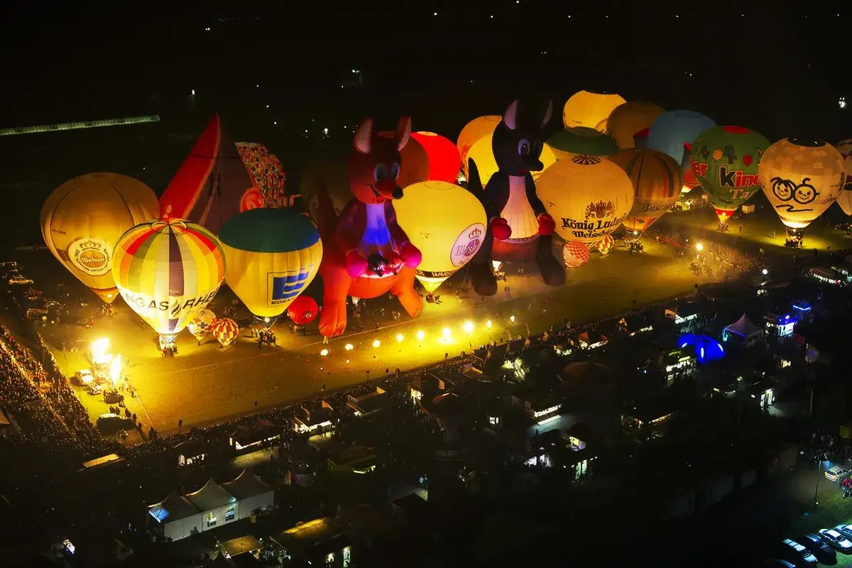 Leuchtende Ballons, darunter zwei riesige Kängurus, erhellen die Nacht bei der Warsteiner Montgolfiade.