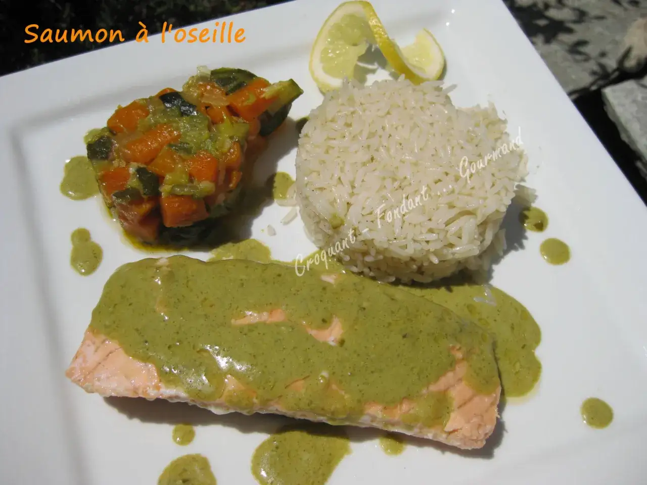 Un d&eacute;licieux saumon &agrave; l'oseille, napp&eacute; d'une sauce verte onctueuse, servi avec du riz et des l&eacute;gumes croquants.
