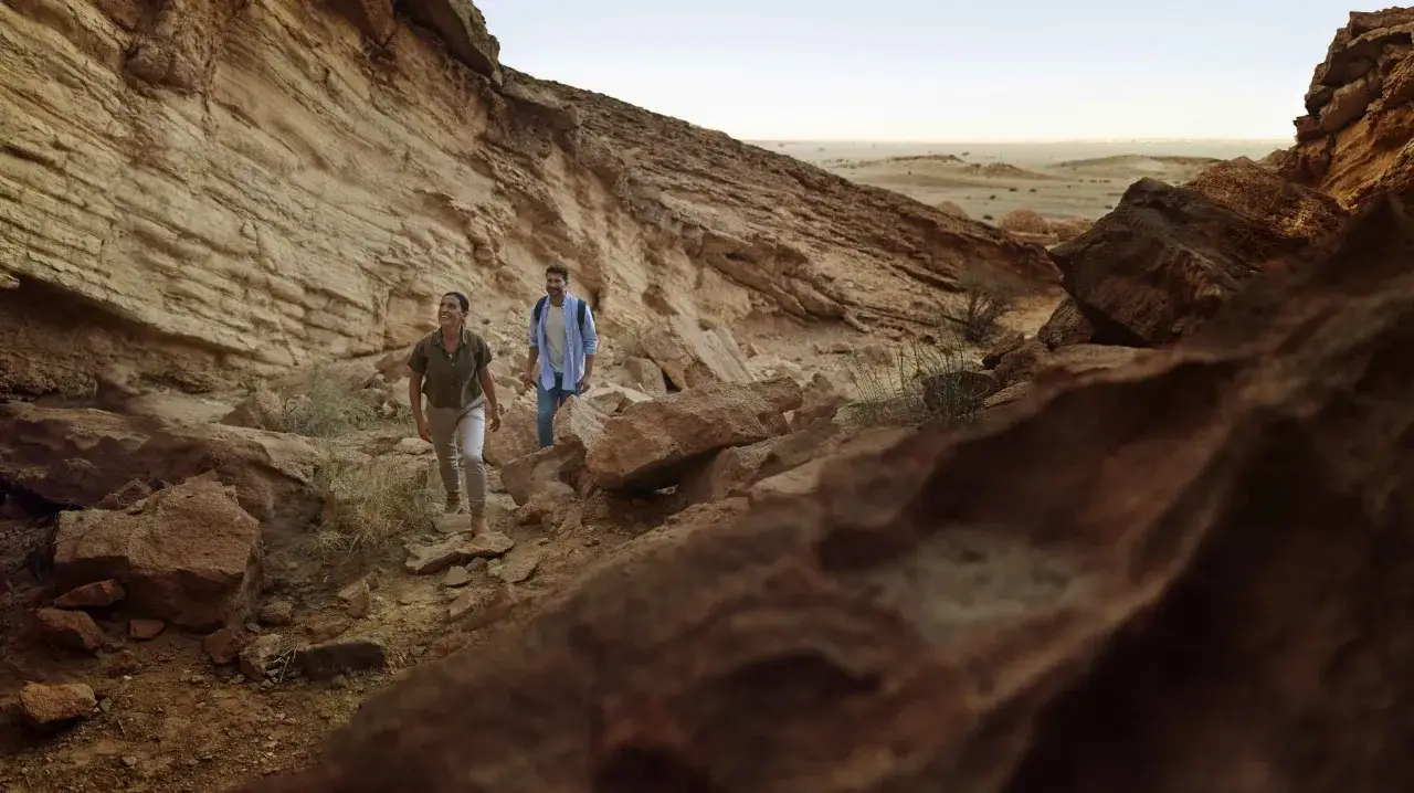 Para idąca szlakiem pośród skalistych zboczy Jebel Hafeet w Al Ain.