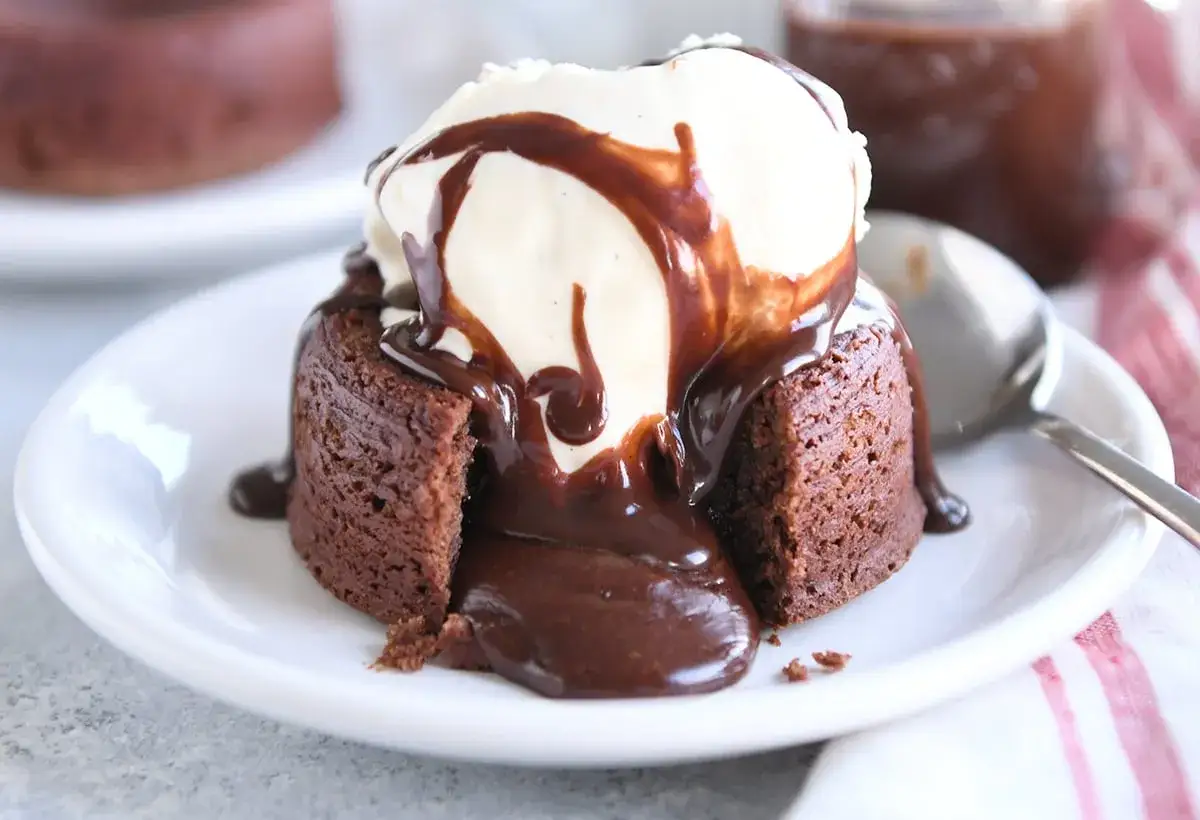 Schokoladen-Lava-Kuchen mit Eis und Schokoladensauce. Ein köstliches Lava cake rezept, das zum Reinbeißen einlädt.