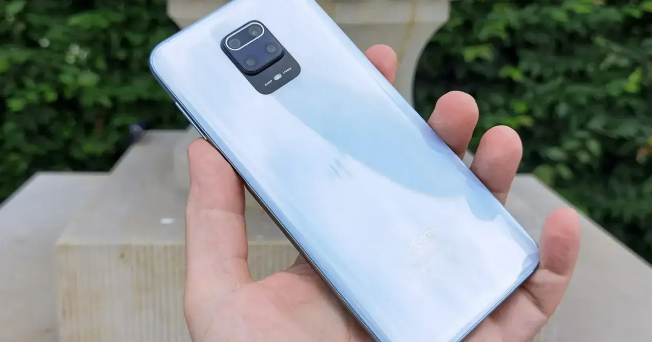 Biały Xiaomi Redmi Note 9 Pro w dłoni, z widocznym modułem aparatu 64MP.