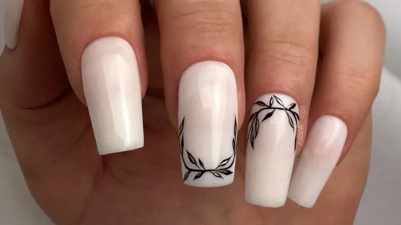 Eleganckie baby boomer nails z subtelnym motywem gałązek w czarnym kolorze.