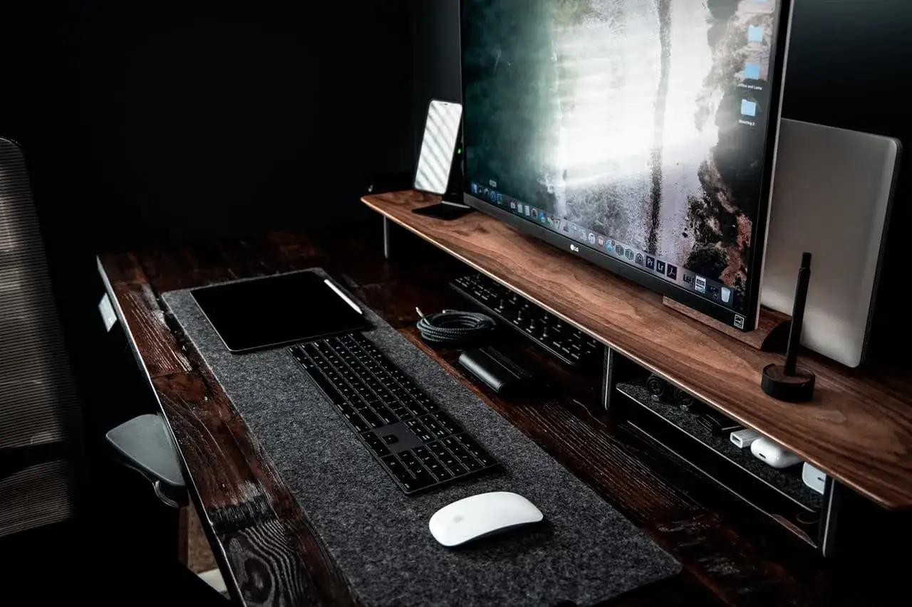 Bureau moderne avec un grand écran pour retouche photo, tablette graphique, clavier et souris.