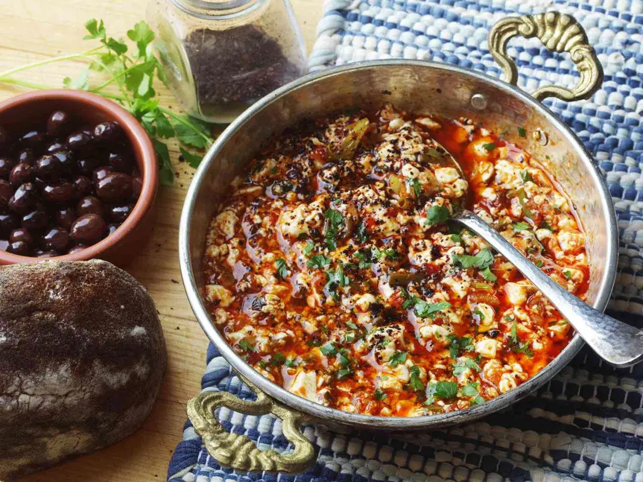 Herzhaftes Menemen ohne Ei, mit Feta, Tomaten und Gew&uuml;rzen, serviert mit Oliven und Brot.