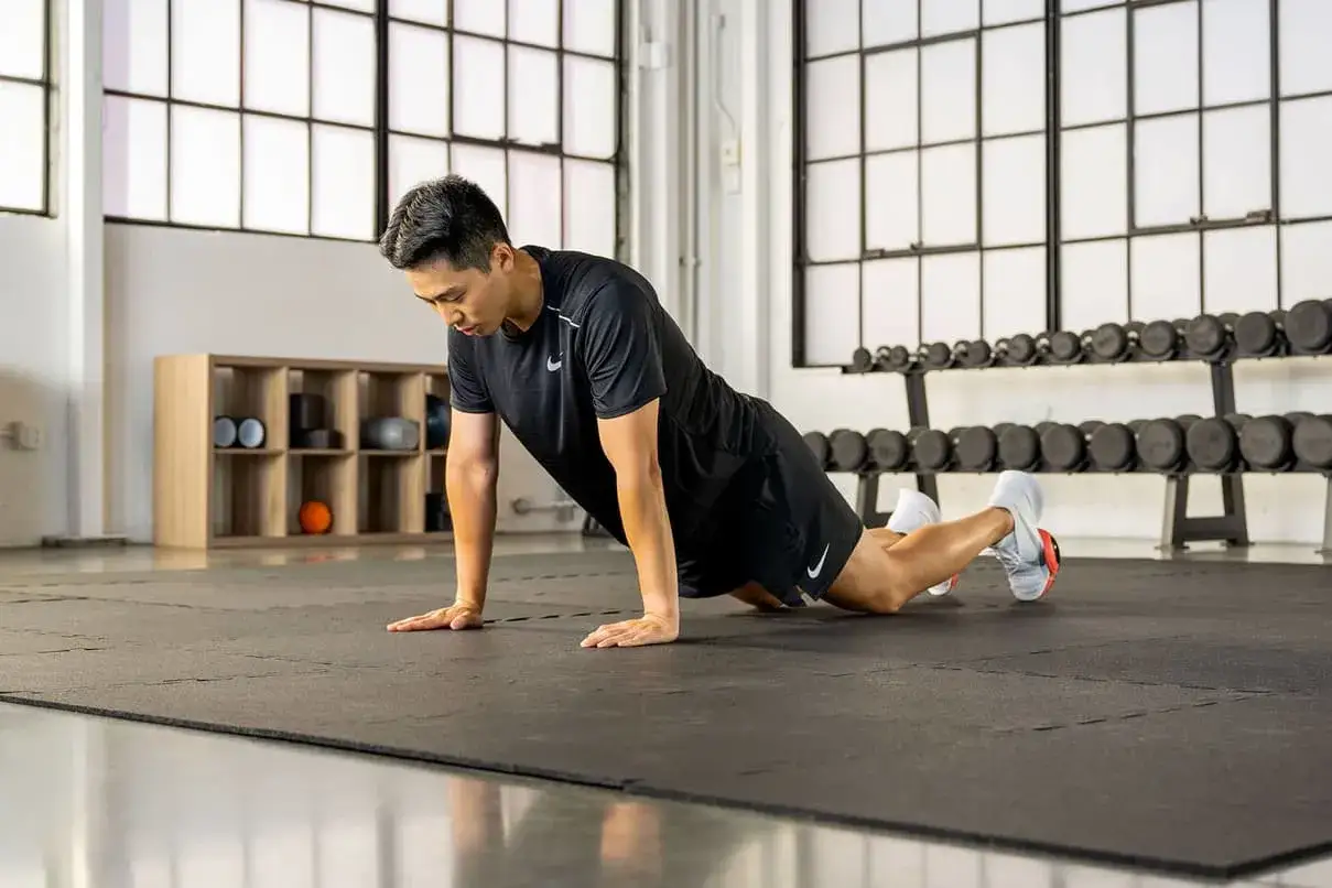 Mężczyzna wykonuje ćwiczenie typu plank, sprawdzając, ile serii jest w stanie zrobić.