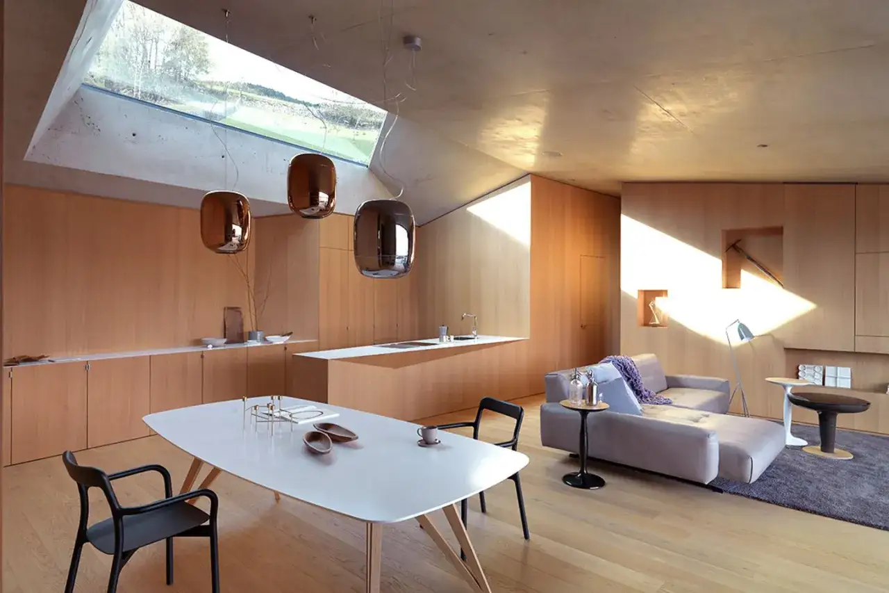 Modernes Wohnzimmer mit Essbereich, viel Holz und einem Dachfenster. Verschiedene **Hartholzarten** schaffen eine warme Atmosph&auml;re.