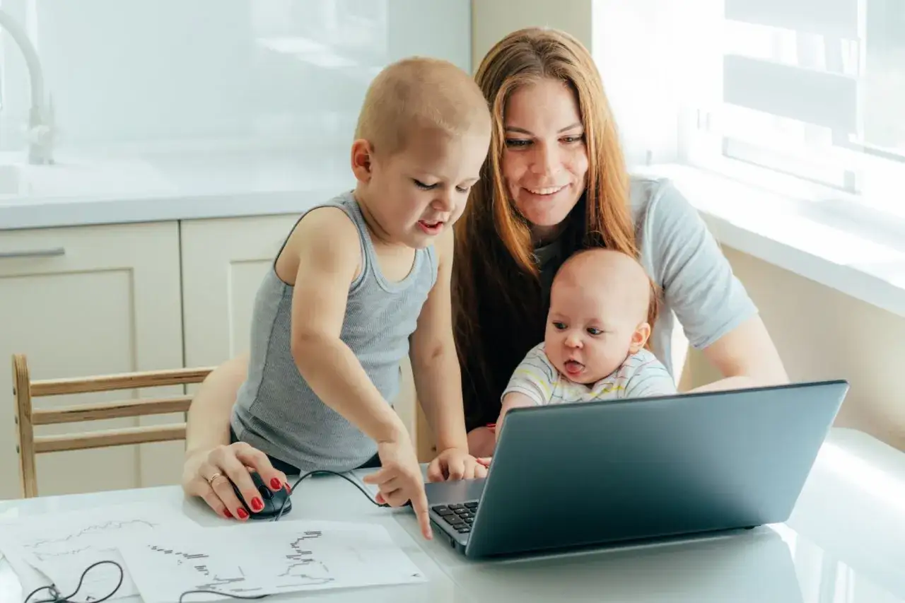 Mama z dwójką dzieci przy laptopie, starszak pokazuje coś na ekranie. To art 188 kp.