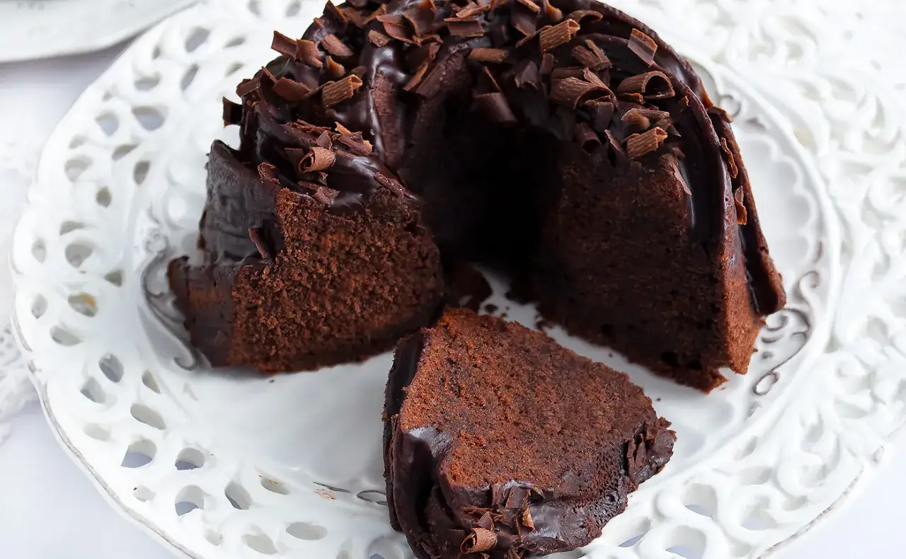 Pyszna babka z mascarpone i kakao, oblana czekoladą i posypana wiórkami.