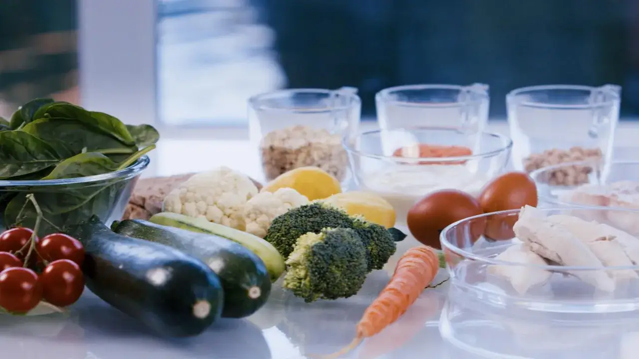 Frische Zutaten wie Spinat, Zucchini, Brokkoli und Karotten für Morbus Crohn Rezepte. Dazu Eier, Joghurt und Hähnchen.