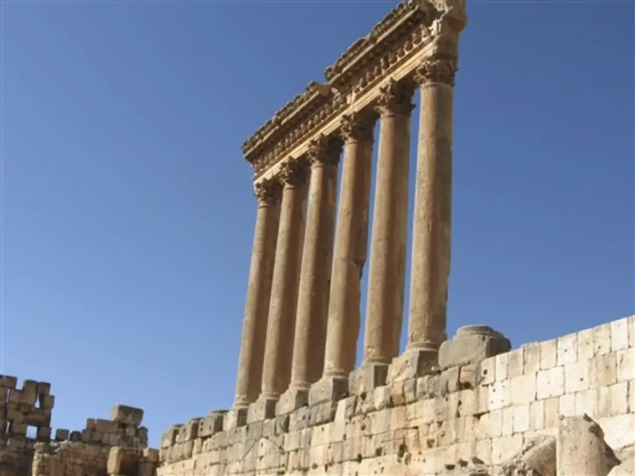 Ancient Roman columns stand tall against a clear blue sky, showcasing the grandeur of Lebanon's historical sites.