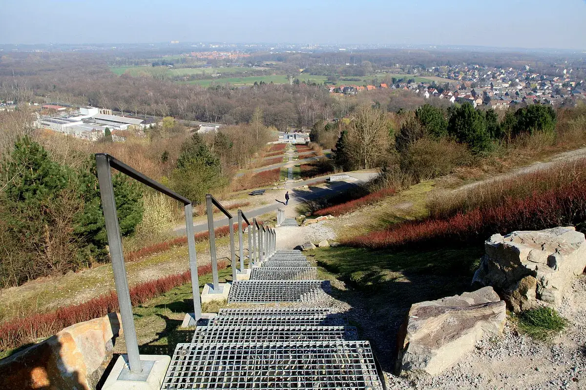 Treppe führt hinab zur Halde Hoheward. Ein Spaziergänger genießt die Aussicht über die Landschaft.