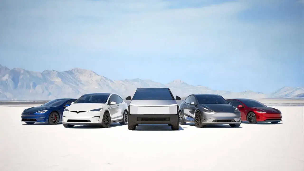 Różne modele Tesli: niebieski sedan, biały SUV, futurystyczny Cybertruck, szary crossover i czerwony sportowy samochód na pustynnym tle.