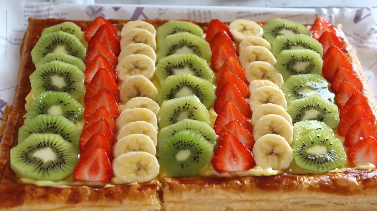 Tartaletas de hojaldre y crema pastelera, cubiertas con filas de fresas, pl&aacute;tanos y kiwi.